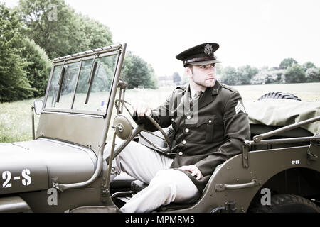 Handsome American WWII GI Army officer in uniform riding Willy Jeep Stock Photo