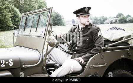 Handsome American WWII GI Army officer in uniform riding Willy Jeep Stock Photo