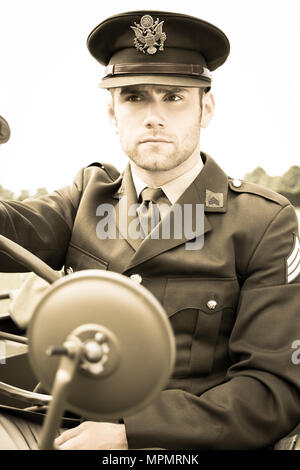 Handsome American WWII GI Army officer in uniform riding Willy Jeep Stock Photo