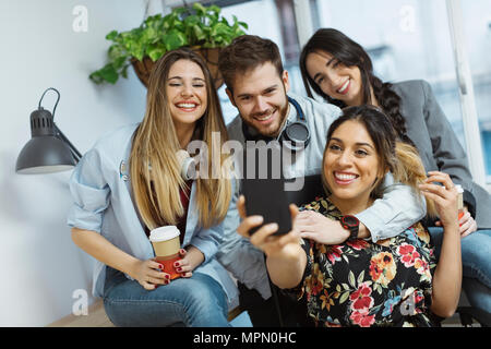 Happy casual coworkers in the office taking a selfie Stock Photo