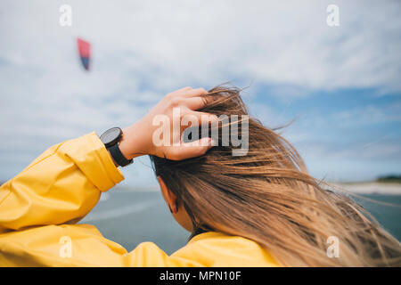 France, Brittany, Landeda, Dunes de Sainte-Marguerite, rear view of long-haired young woman at the coast Stock Photo