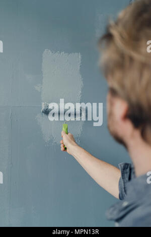 Man painting wall with paint roller Stock Photo