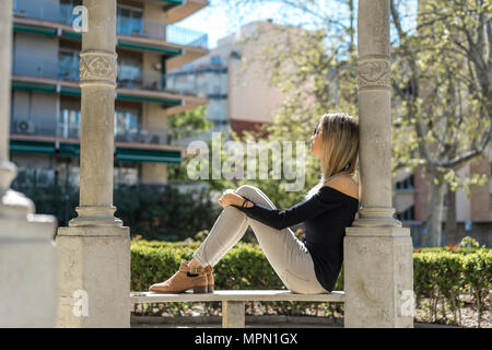 Young woman relaxing on bench Stock Photo