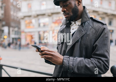 Man in the city checking cell phone Stock Photo