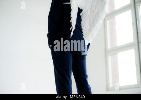 Businessman wearing suit and angel's wings, rear view Stock Photo