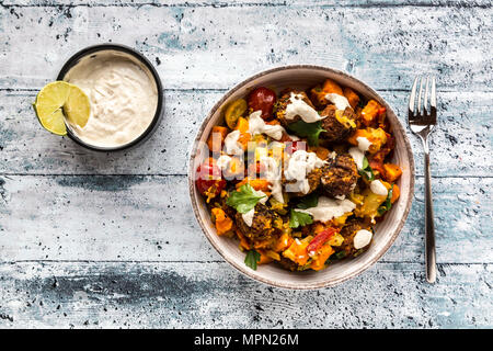 Vegetarian bowl with sweet potato, tomato and falafel, yogurt dip and parsley Stock Photo