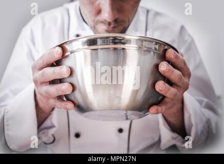 Kitchen Chef Cooking Time. Caucasian Chef with Stainless Steel Bowl in Hands During Food Preparation. Stock Photo