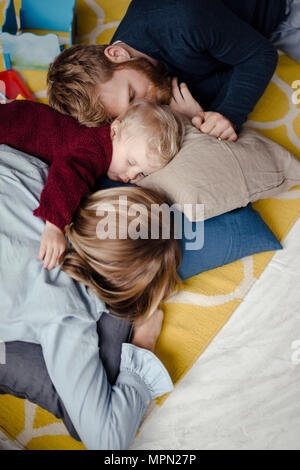 Tiered family resting together on the floor after playing Stock Photo