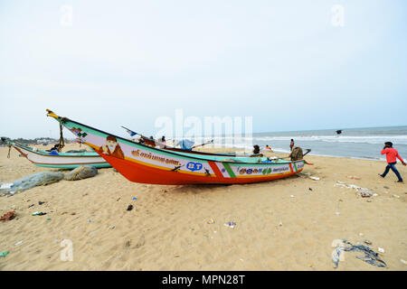 Fishermen and fishing boats on Marina beach in Chennai, India. Stock Photo