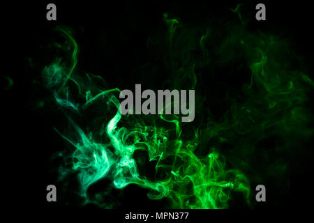 Dense multicolored smoke of   green and yellow colors on a black isolated background. Stock Photo