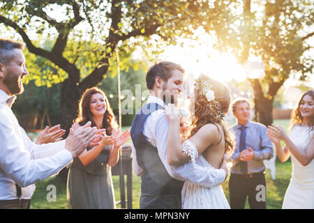 Bride and groom dancing at wedding reception outside in the backyard. Stock Photo