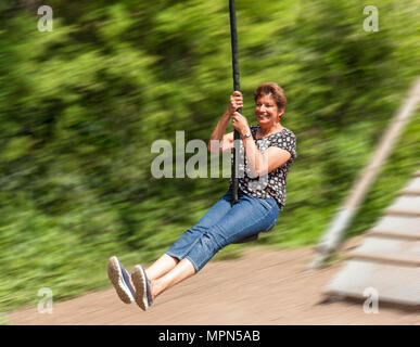 Middle age woman on a zip wire. Stock Photo