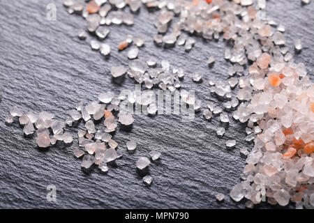 crystals of coarse grained salt on black background - close up Stock Photo