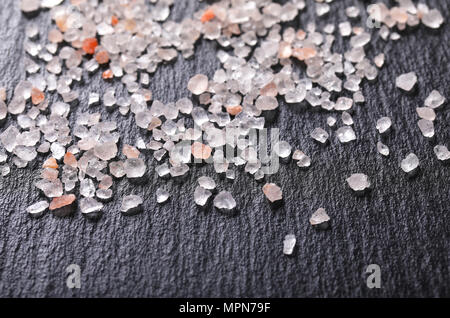 crystals of coarse grained salt on black background - close up Stock Photo