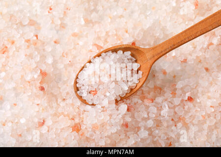 spoon of coarse grained salt on coarse grained salt background Stock Photo