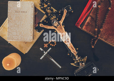 top view of cross with Jesus and bibles on wooden table Stock Photo