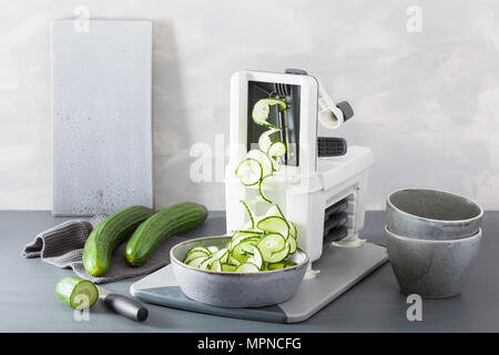 spiralizing cucumber vegetable with spiralizer Stock Photo