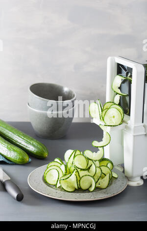 spiralizing cucumber vegetable with spiralizer Stock Photo