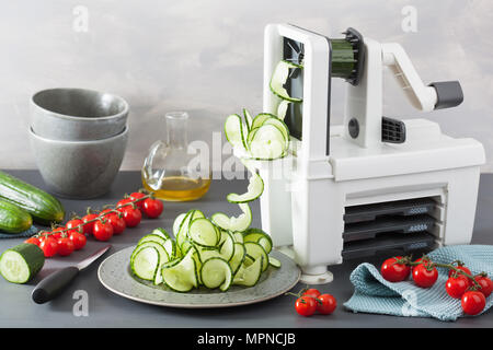 spiralizing cucumber vegetable with spiralizer Stock Photo