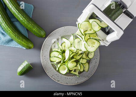 spiralizing cucumber vegetable with spiralizer Stock Photo