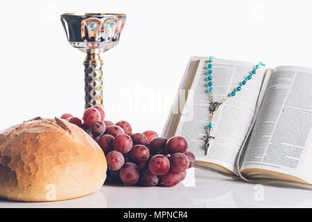 open holy bible, food, chalice and christian cross on white for Holy Communion Stock Photo