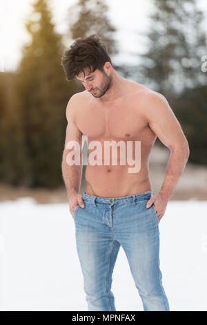 Young Muscular Man Posing Outside in a Tank Top and Jeans · Free