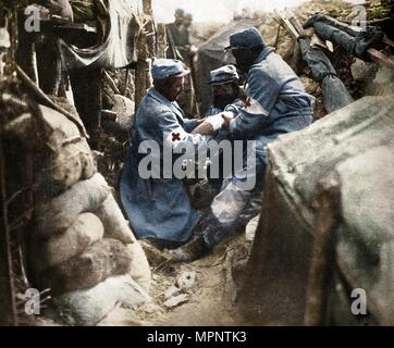 'First aid to a wounded man in one of the French trenches', 1915. Artist: Unknown. Stock Photo