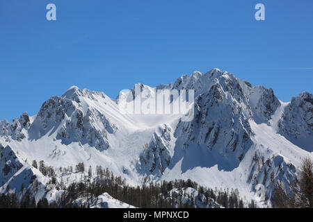 wide panormaric view of moutains with white snow in winter from Lussari Mount in Northern Italy Stock Photo