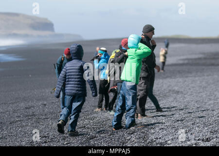 Vik, Iceland. 24th May, 2018.  Weather.  A group of American tourists on the dangerous beach in Southern Iceland.  Police in South Iceland have issued a warning to visitors at the black sand beaches near the village of Vík in South Iceland.  According to the weather forecast ocean conditions are expected to be particularly rough, with larger than usual waves.  Police in South Iceland warns that conditions at the beaches can easily become very dangerous in this kind of weather. A strong wind blowing from the south will grow the waves which can be very powerful, even under normal conditions. Stock Photo