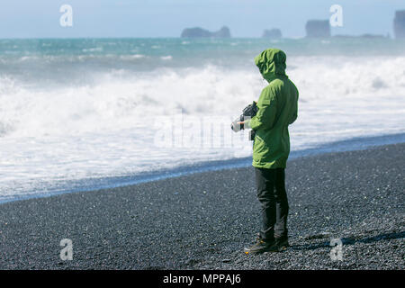 Vik, Iceland. 24th May, 2018.  Weather.  A group of American tourists on the dangerous beach in Southern Iceland.  Police in South Iceland have issued a warning to visitors at the black sand beaches near the village of Vík in South Iceland.  According to the weather forecast ocean conditions are expected to be particularly rough, with larger than usual waves.  Police in South Iceland warns that conditions at the beaches can easily become very dangerous in this kind of weather. A strong wind blowing from the south will grow the waves which can be very powerful, even under normal conditions. Stock Photo