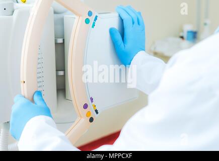 Professional Medical Equipment. Hospital Technician with Hands on X Ray Machine. Stock Photo