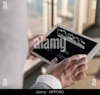 Woman using tablet with data emerging from screen Stock Photo