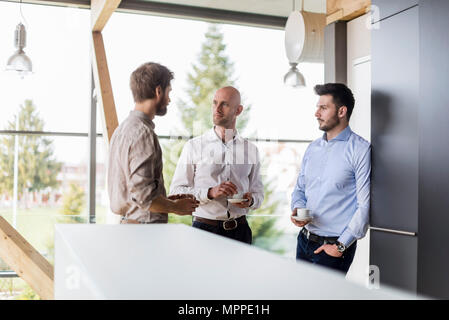 Three businessmen talking during coffee break Stock Photo
