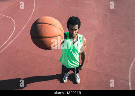 Young basketball player holding ball