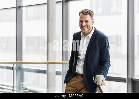 Portrait of smiling businessman having a coffee break Stock Photo