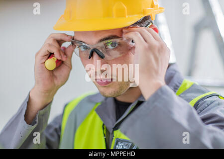 Electrician putting on protective glasses Stock Photo