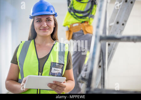 Portrait of smiling woman with tablet on construction site Stock Photo