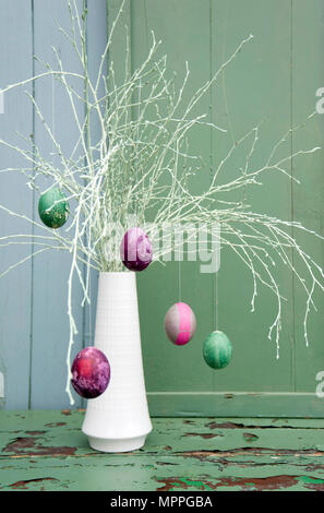 Sprayed twigs with dyed Easter eggs Stock Photo