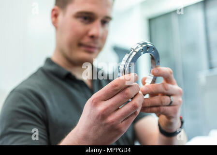 Man examining workpiece in factory Stock Photo