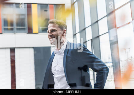 Smiling businessman standing in office building Stock Photo