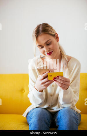 A person seated with a smartphone and a credit card Stock Photo - Alamy