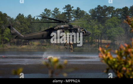 U.S. Army Capt. Timothy Cox and 1st Lt. Andy Harvey, 3rd Chemical Brigade Rangers, jump out of a UH-60 Black Hawk helicopter during the Best Ranger Competition 2017 in Fort Benning, Ga., April 9, 2017. The 34th annual David E. Grange Jr. Best Ranger Competition 2017 is a three-day event consisting of challenges to test competitor's physical, mental, and technical capabilities. (U.S. Air Force photo by Staff Sgt. Marianique Santos) Stock Photo