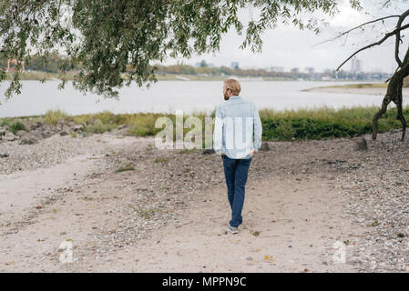 Germany, Duesseldorf, back view of man standing on the beach Stock Photo