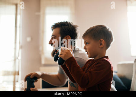 Little boy playing computer game with his father at home Stock Photo