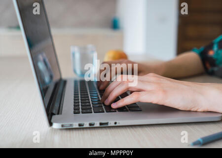 Close-up of woman at home using laptop on table Stock Photo