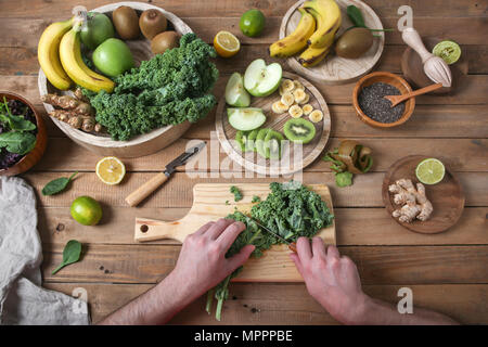 Man preparing green smoothie cutting kale Stock Photo