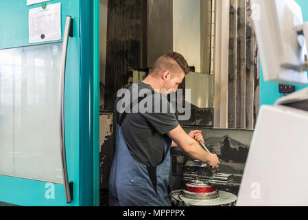 Man working at machine in factory Stock Photo