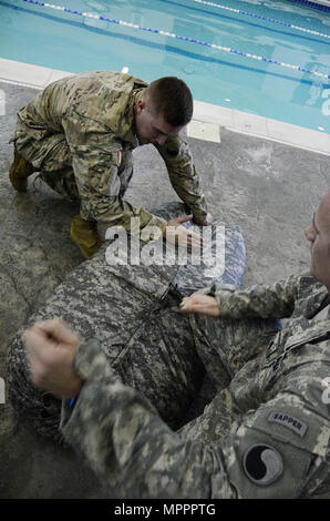 Soldiers from the 229th Brigade Engineer Battalion, 116th Infantry Brigade Combat Team, construct and utilize a poncho raft at Gold’s Gym in Fredericksburg, Virginia, while preparing for the Best Sapper Competition at Fort Leonard Wood, Missouri. The exercise builds engineering, problem-solving, teamwork, and technical proficiency for Sapper-specific tasks. Stock Photo