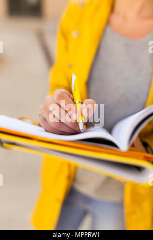 Close-up of woman taking notes outdoors Stock Photo