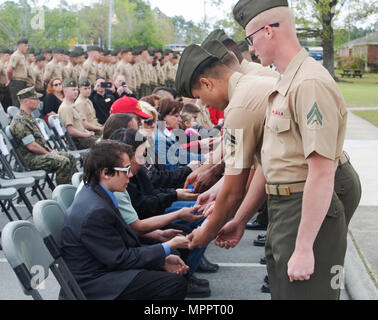 Marines hand ceremonial purple heart pins to family of fallen Marines with 2nd Light Armored Reconnaissance Battalion, 2nd Marine Division during a memorial ceremony at Camp Lejeune, N.C., April 7, 2017. The ceremony honored fallen Marines as well as families and friends of the 2nd LAR community. (U.S. Marine Corps photo by Lance Cpl. Raul Torres) Stock Photo